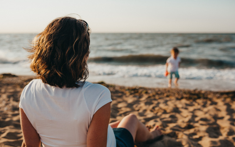 Sous la surveillance de sa maman, un enfant se régale en Bord de mer (photo Xavier Mouton @Unsplash)